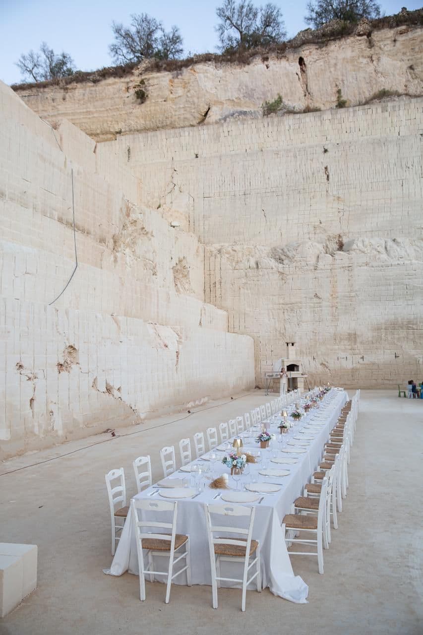 La tavolata al crepuscolo tra le alte pareti di pietra della cava